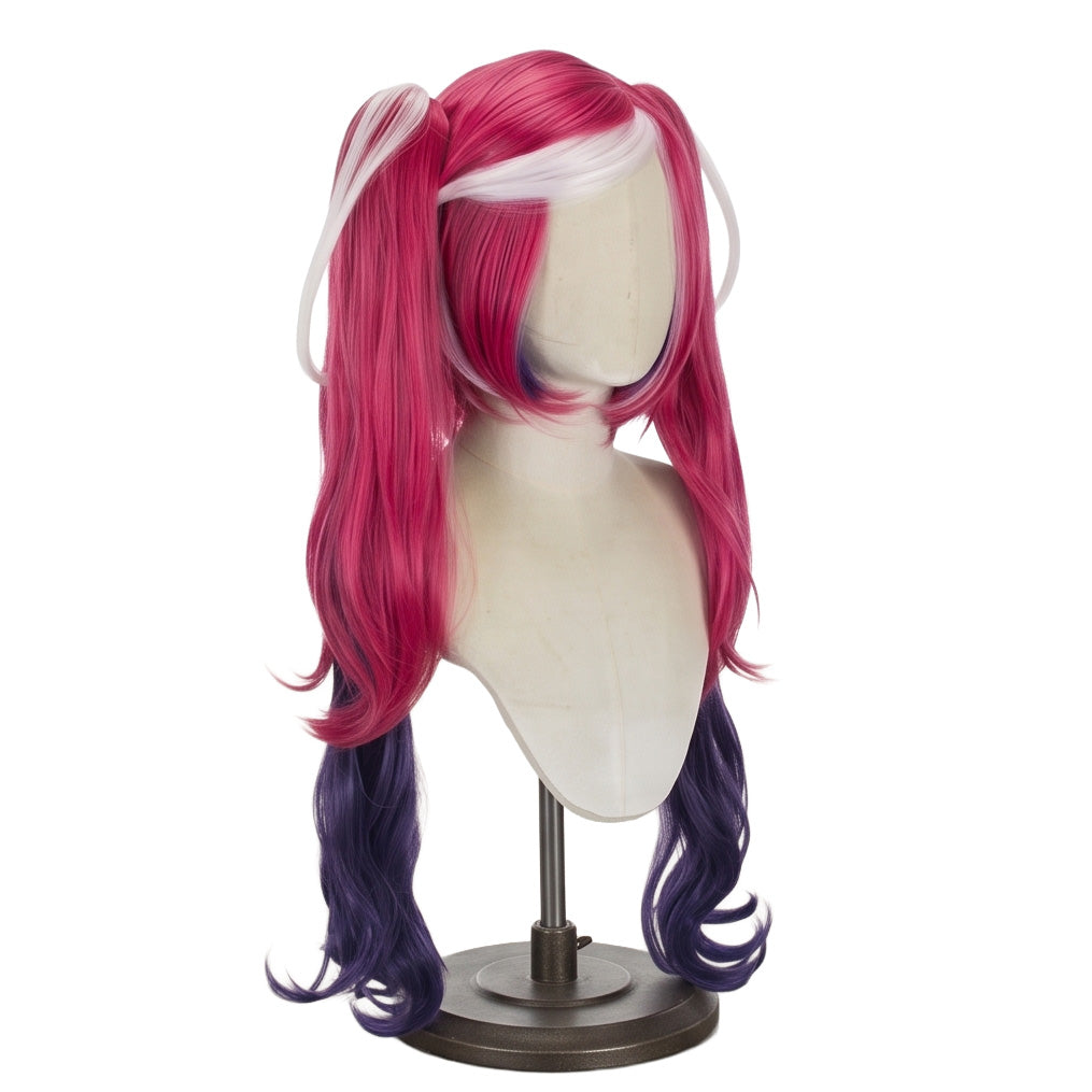 Three-quarter view of Velvette cosplay wig showing long curly desire-red pigtails, bangs, navy-blue inner sections, and white swirl accents